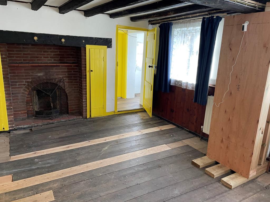Lot: 112 - COTTAGE WITH GARDENS IN NEED OF UPDATING - Living room with beams and fireplace